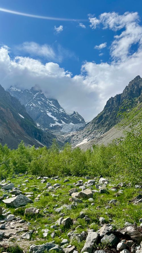 Free Stunning view of snow-capped Caucasus peaks and verdant valley under a bright blue sky. Stock Photo