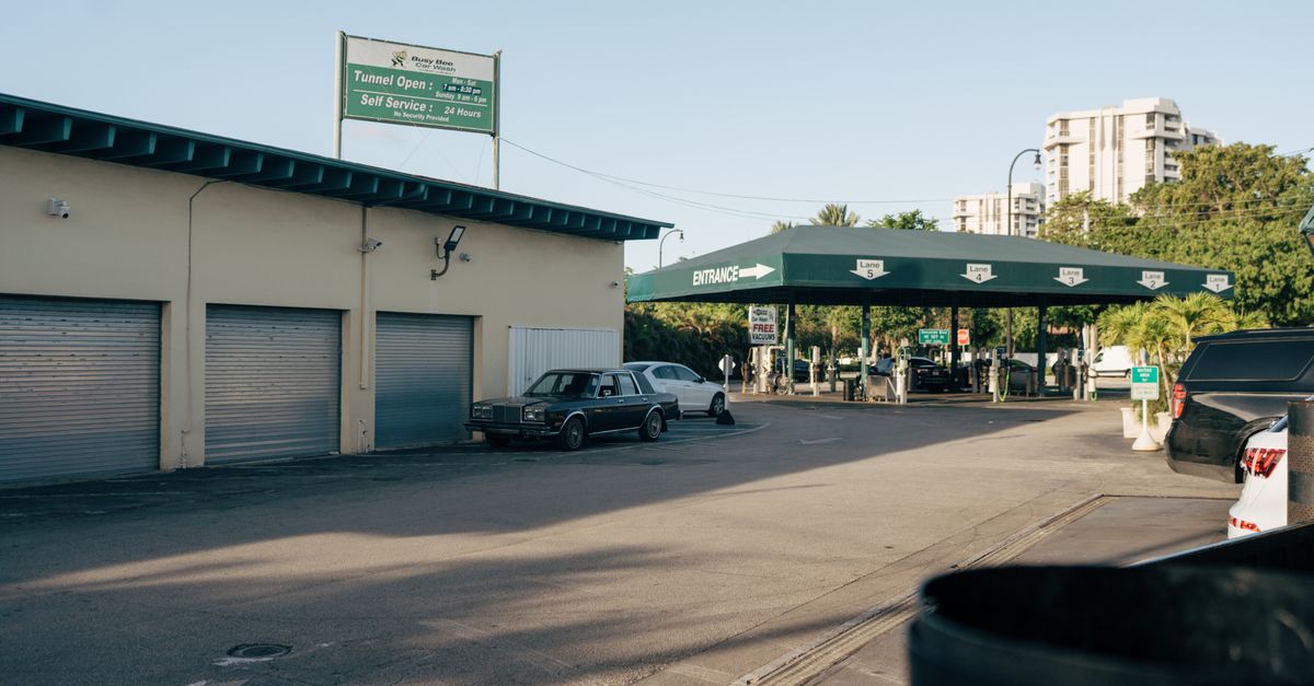 Photo by Sami Abdullah Urban car wash and gas station with vintage car and modern architecture in daylight.