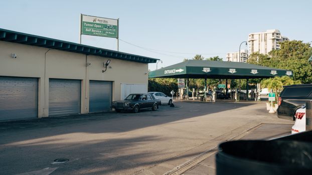 Photo by Sami Abdullah Urban car wash and gas station with vintage car and modern architecture in daylight.