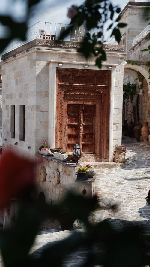 Free Architectural detail of a historic stone building highlighting a wooden doorway and courtyard. Stock Photo