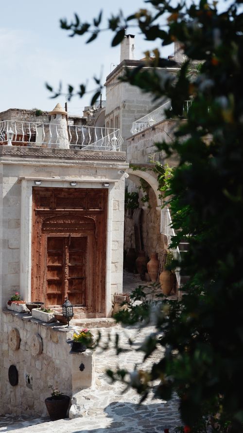 Free Rustic wooden door in a charming Mediterranean stone courtyard setting. Stock Photo