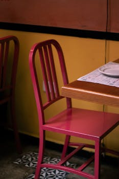 Red metal chair in a colorful restaurant interior with a warm ambiance, ideal for dining concepts.