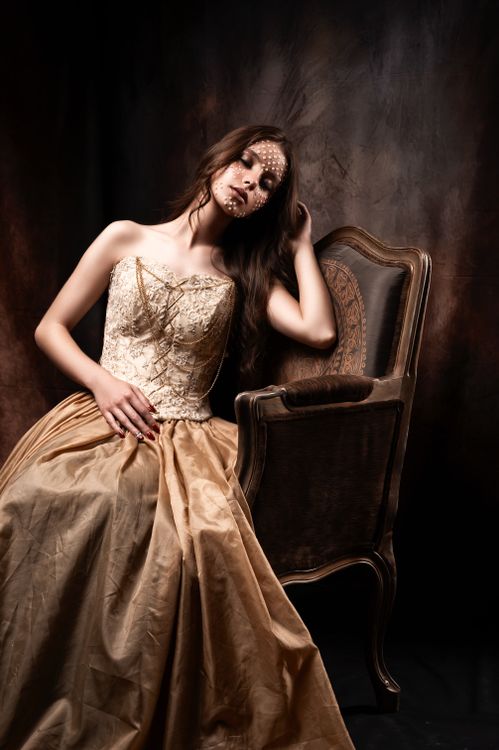 Elegant Woman in Vintage Dress Sitting by Chair · Free Stock Photo