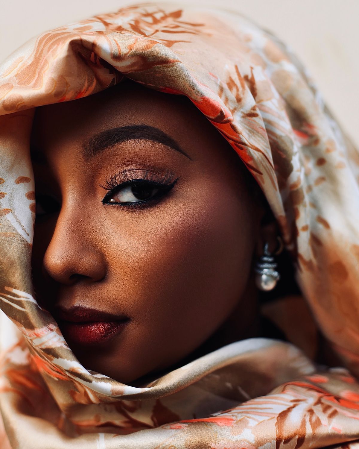 Portrait of a Woman in a Patterned Headscarf · Free Stock Photo