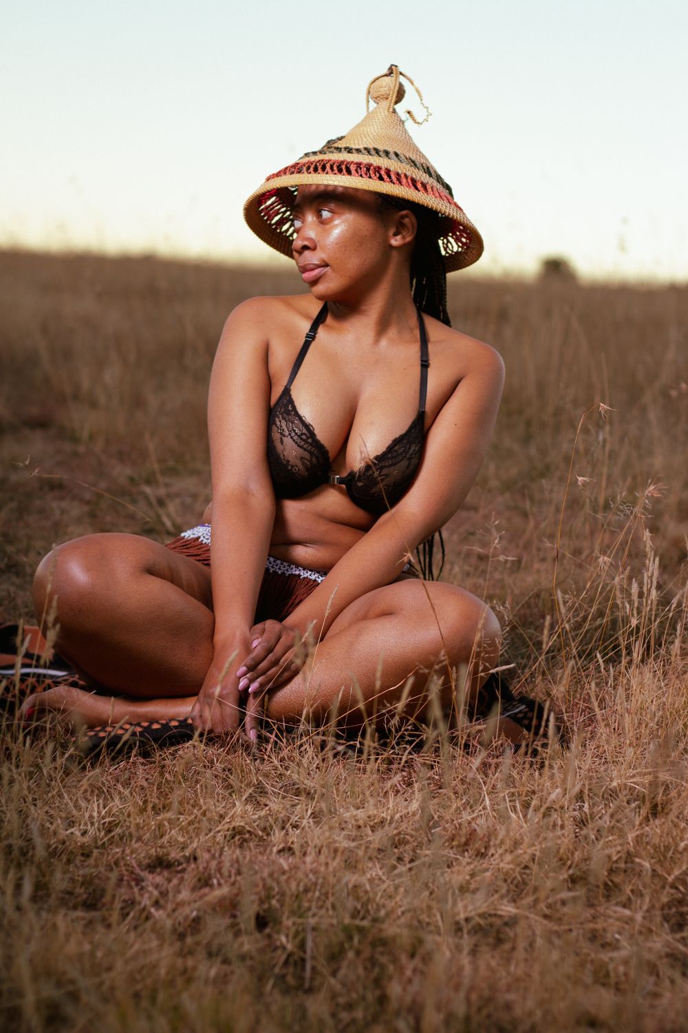 Woman in Traditional Hat Sitting in Field · Free Stock Photo