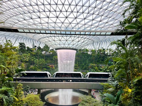 Futuristic indoor waterfall and greenery at Jewel Changi Airport, Singapore.