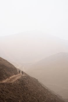 Two hikers on a foggy mountain path in Pachacamac, Lima, Perú.