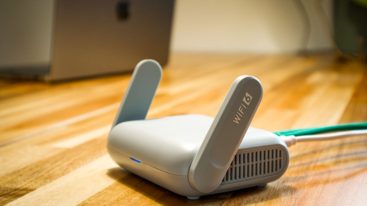 A sleek WiFi 6 router with antennas and cable on a wooden desk, perfect for modern home networks.