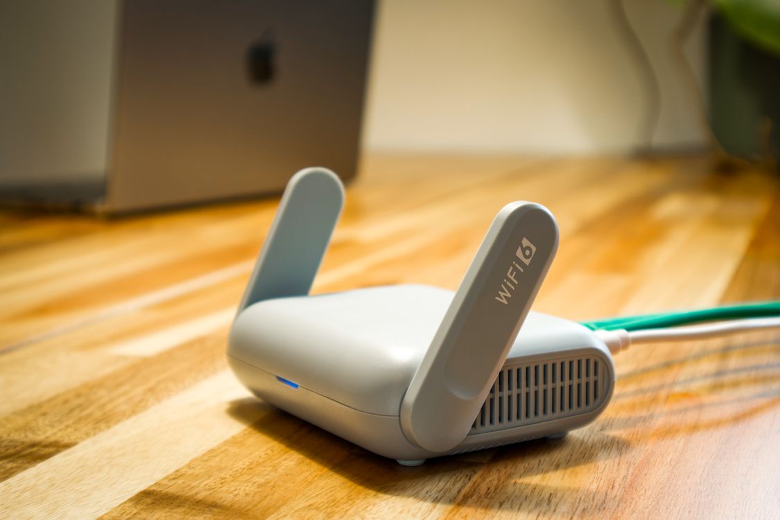 Moderan WiFi 6 ruter s antenama na drvenom stolu