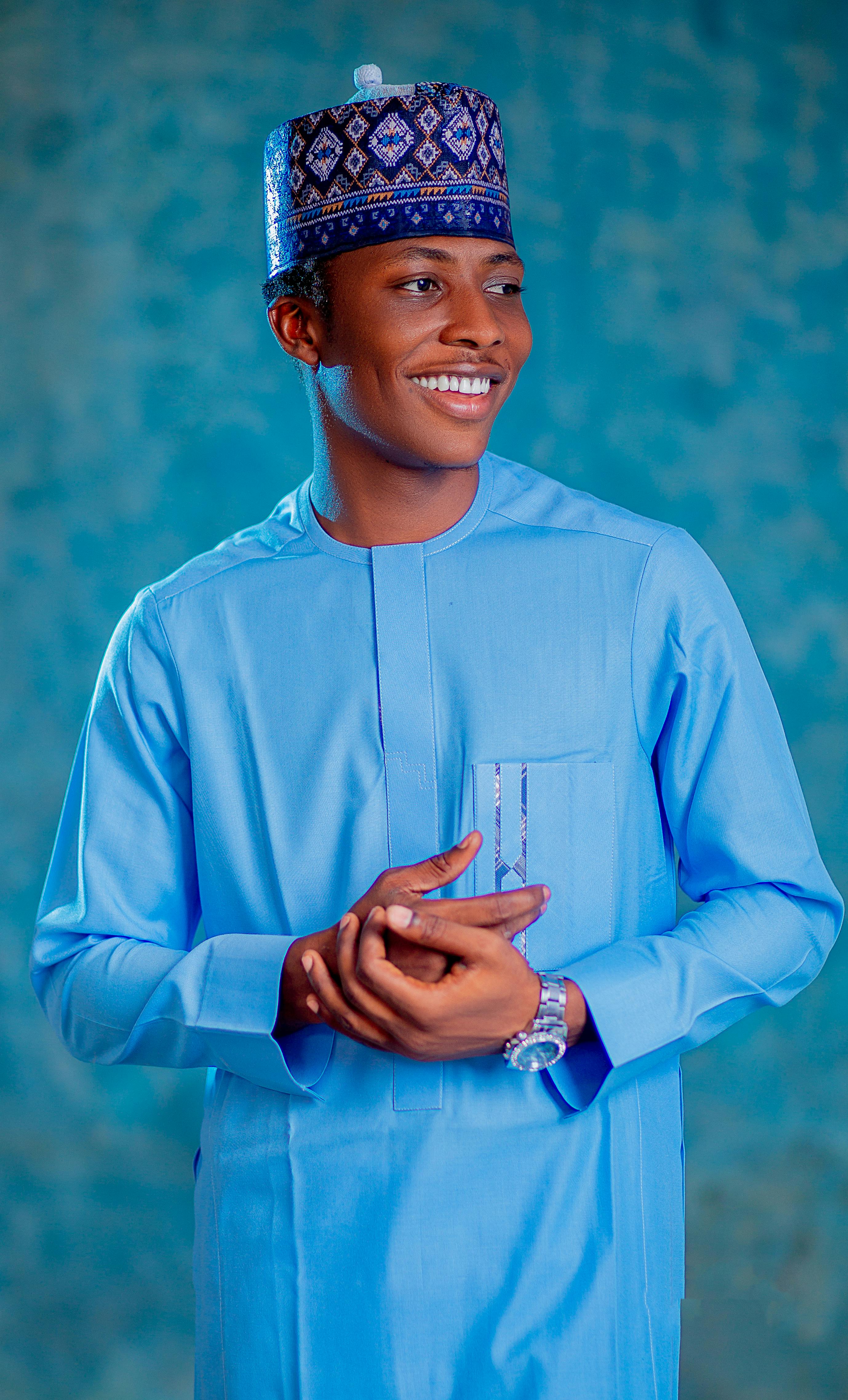 Bright portrait of a man in traditional blue attire and patterned cap.