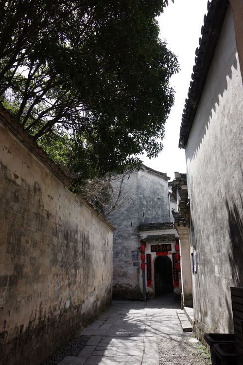 Free Narrow alleyway in ancient Chinese village with red lanterns and traditional architecture. Stock Photo