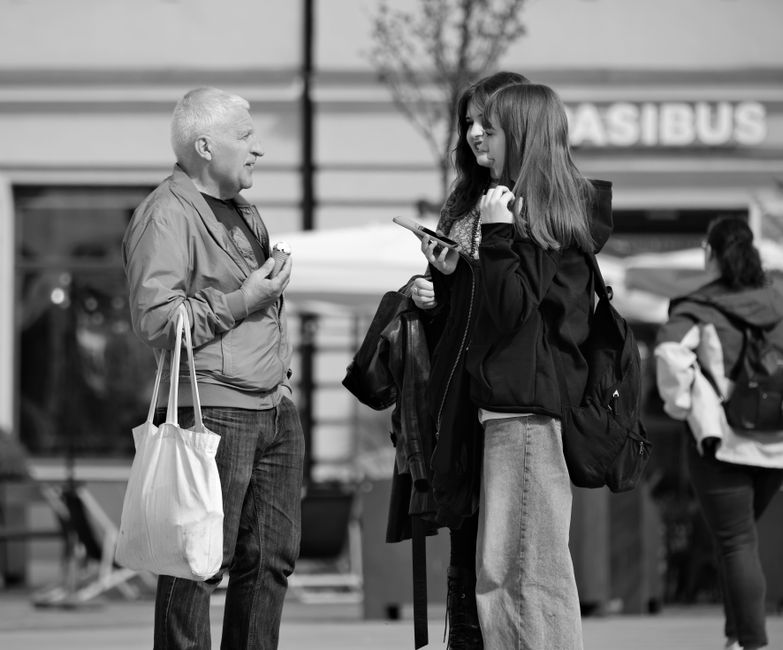 Candid street scene with three people engaging in a vibrant conversation.