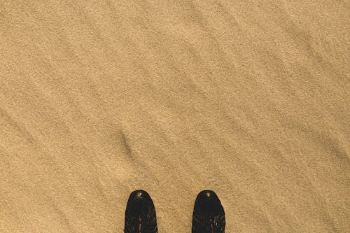 Pair of Black Shoes On Sand