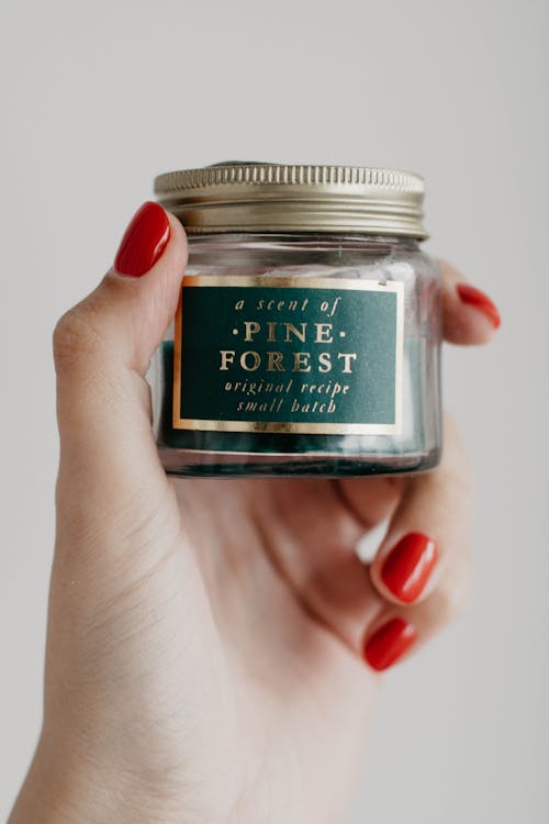 Woman's Hand Holding A Pine Forest Bottle