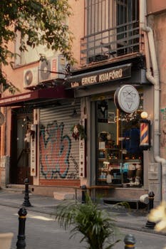 Charming vintage barber shop on an urban street, showcasing colorful graffiti and cozy atmosphere.