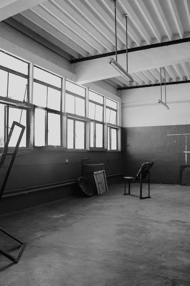 An empty studio hall with tall factory windows — photo by Khalifa Yahaya on Pexels