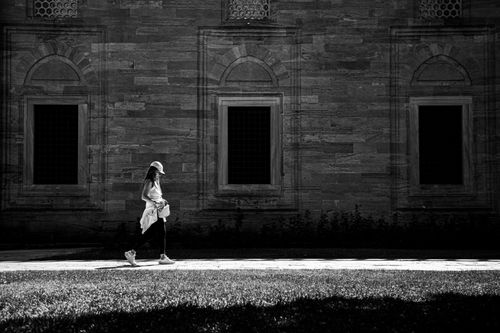 Free A woman walks past a historic building in Istanbul, captured in striking black and white. Stock Photo