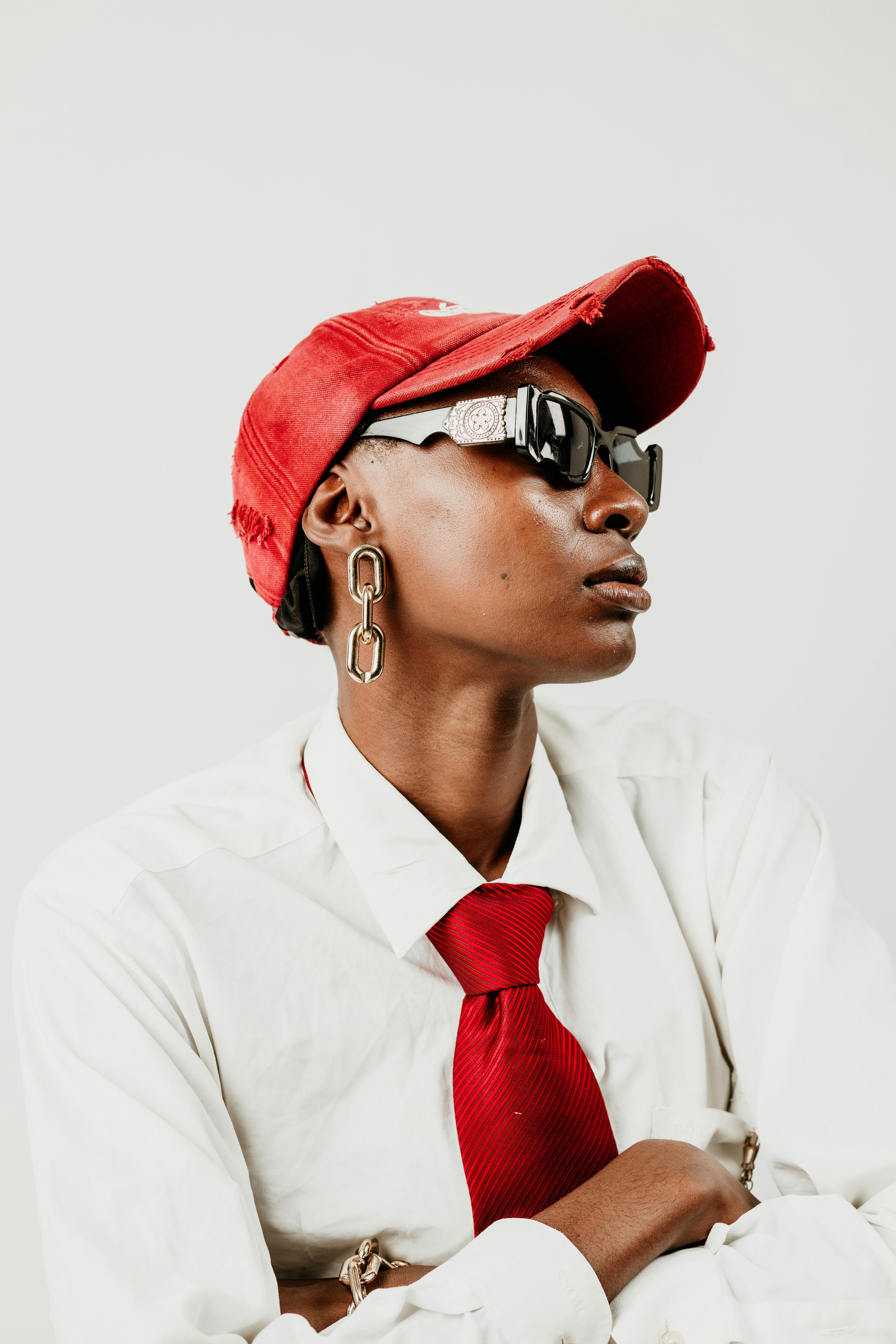 gratis Modern modeportret met rode accessoires, vastgelegd met veel contrast. Stockfoto