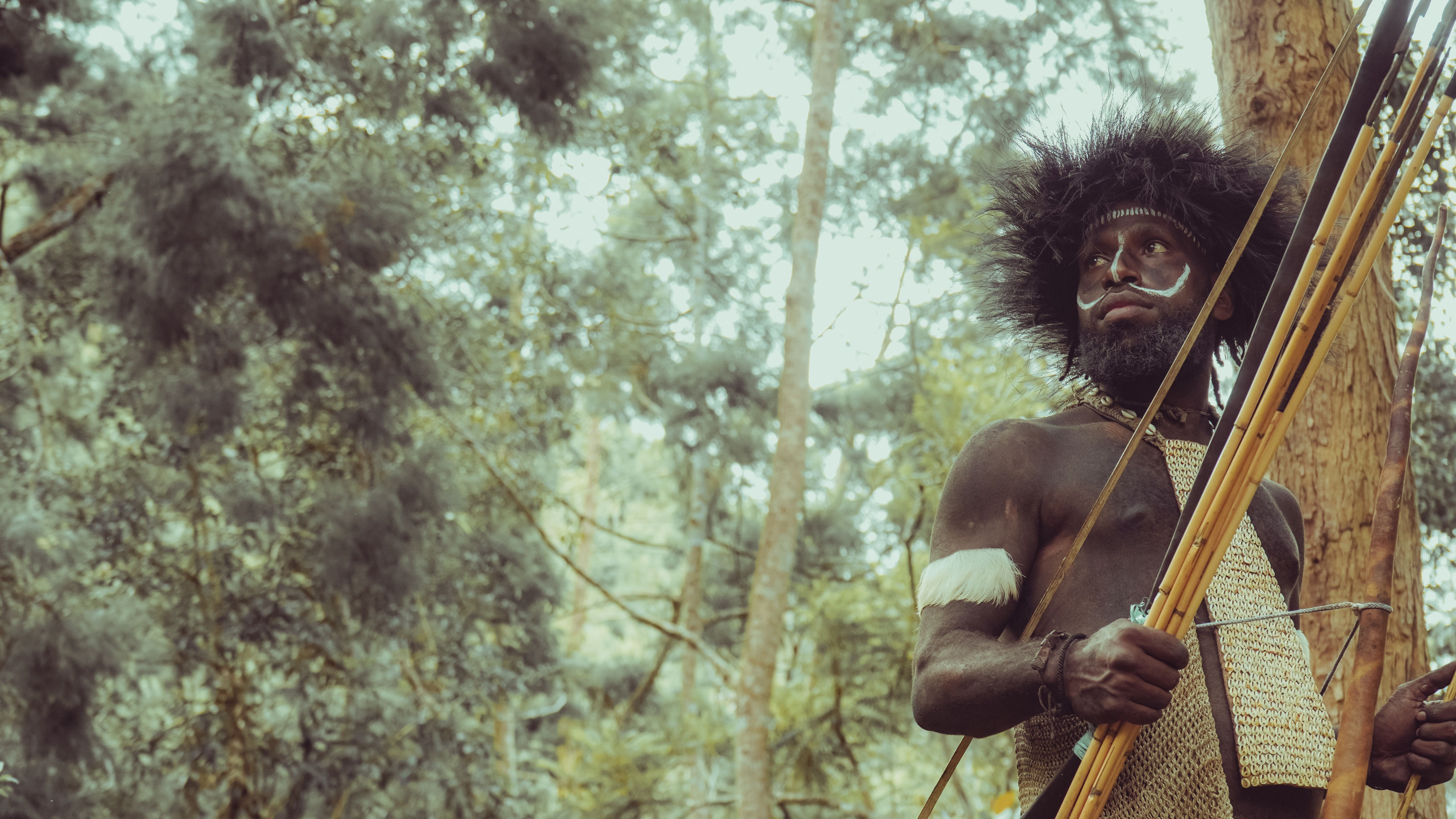 Traditional archer in forest setting with handmade bow