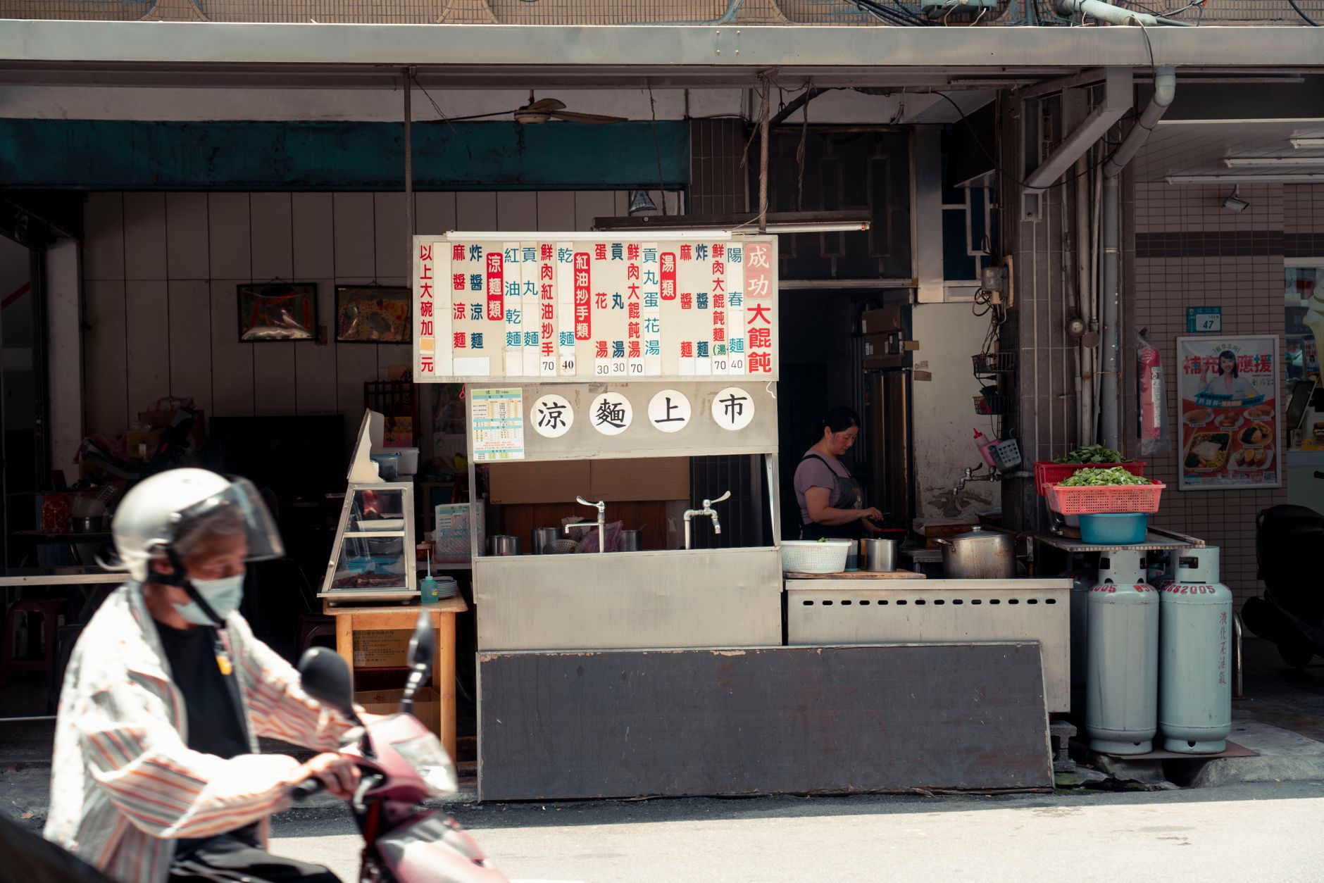 Traditional noodle stall with a scooter passing by in New Taipei City, Taiwan.