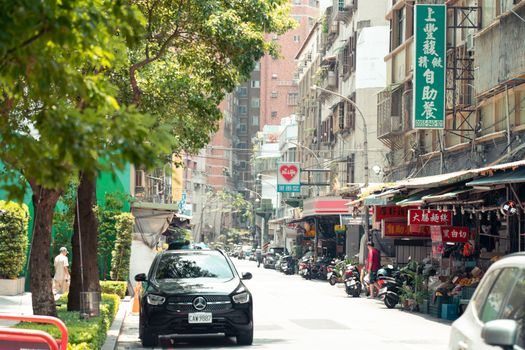 A bustling summer day on a street in New Taipei City, featuring local shops and lively urban life.