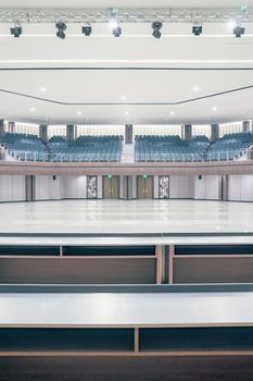 Spacious theater interior with empty seating and stage, showcasing modern architecture.