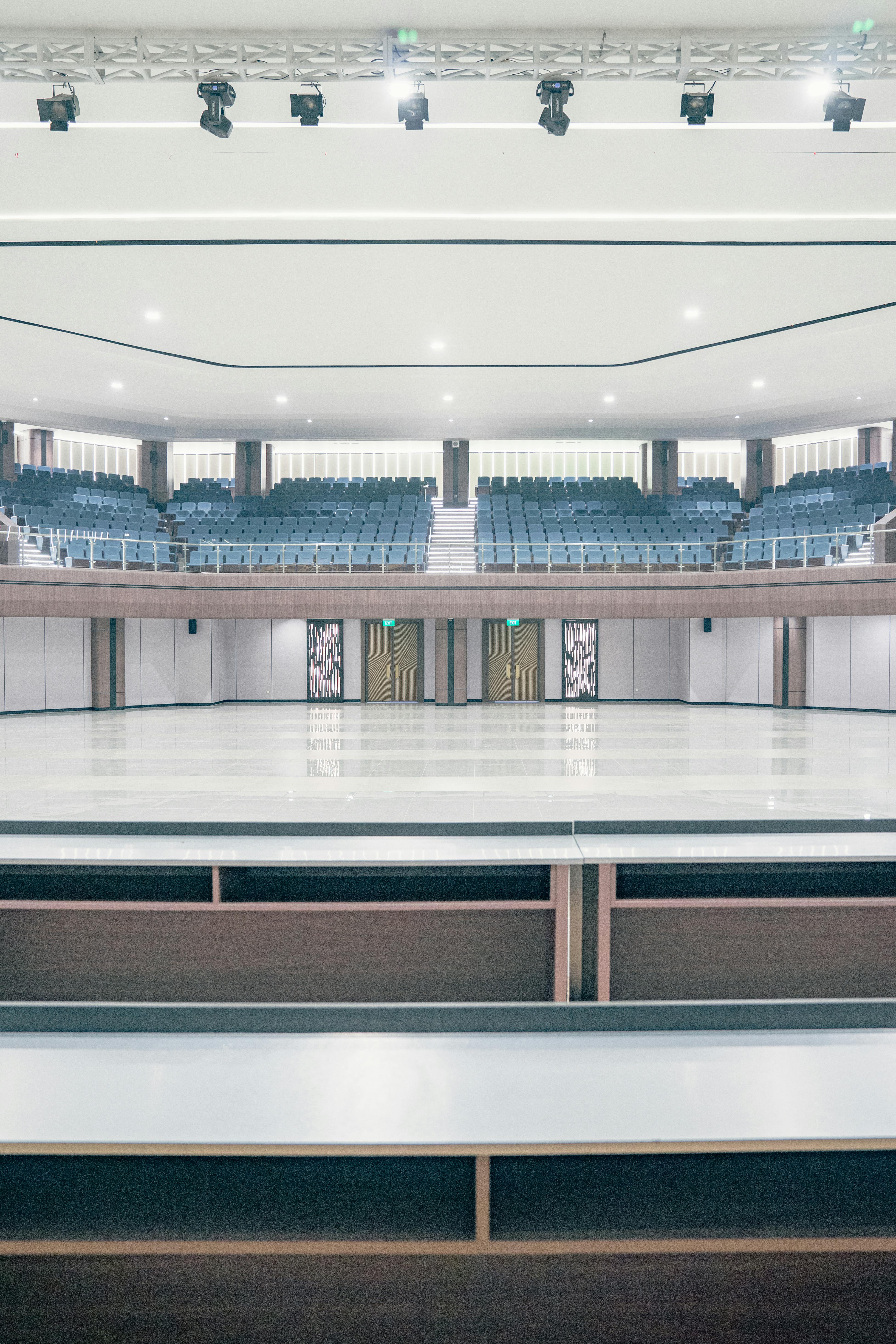 grátis Interior espaçoso do teatro com assentos e palco vazios, exibindo arquitetura moderna. Foto profissional