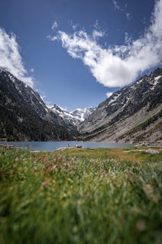 Breathtaking alpine scenery featuring a tranquil lake, majestic mountains, and a vibrant sky.