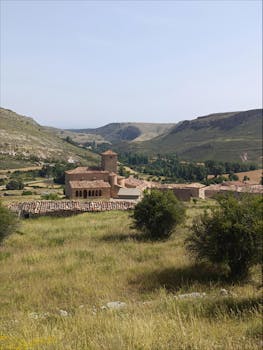 Explore a stunning view of a medieval village nestled in Soria's mountainous landscape.