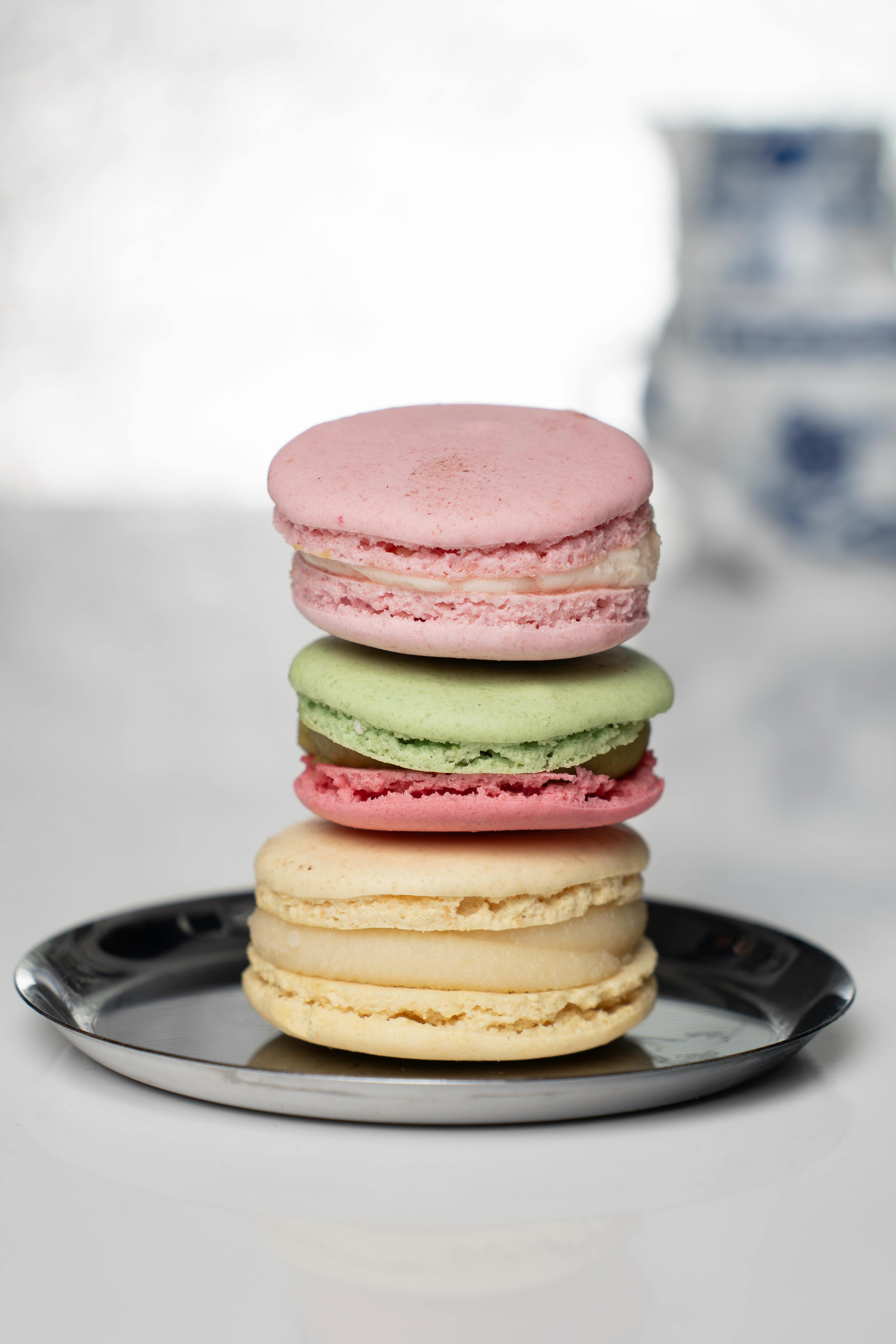 Elegant stack of colorful macarons on a reflective plate, perfect for food photography.