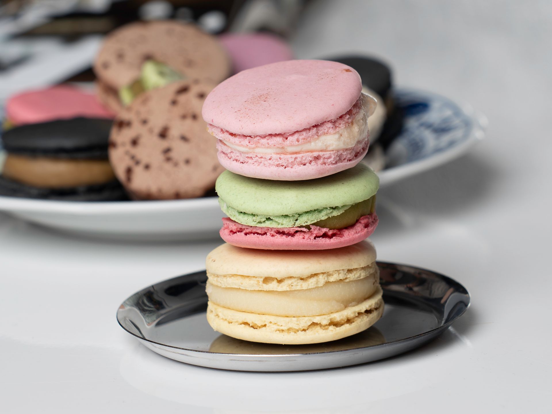 A stack of vibrant macarons displayed on plates, highlighting French pastry art.