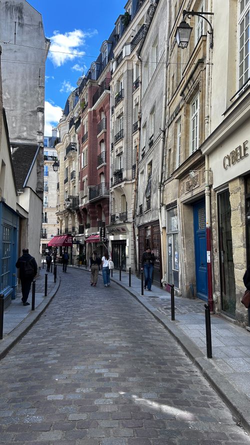 Free Quaint Paris street with classic architecture capturing local life and European charm. Stock Photo