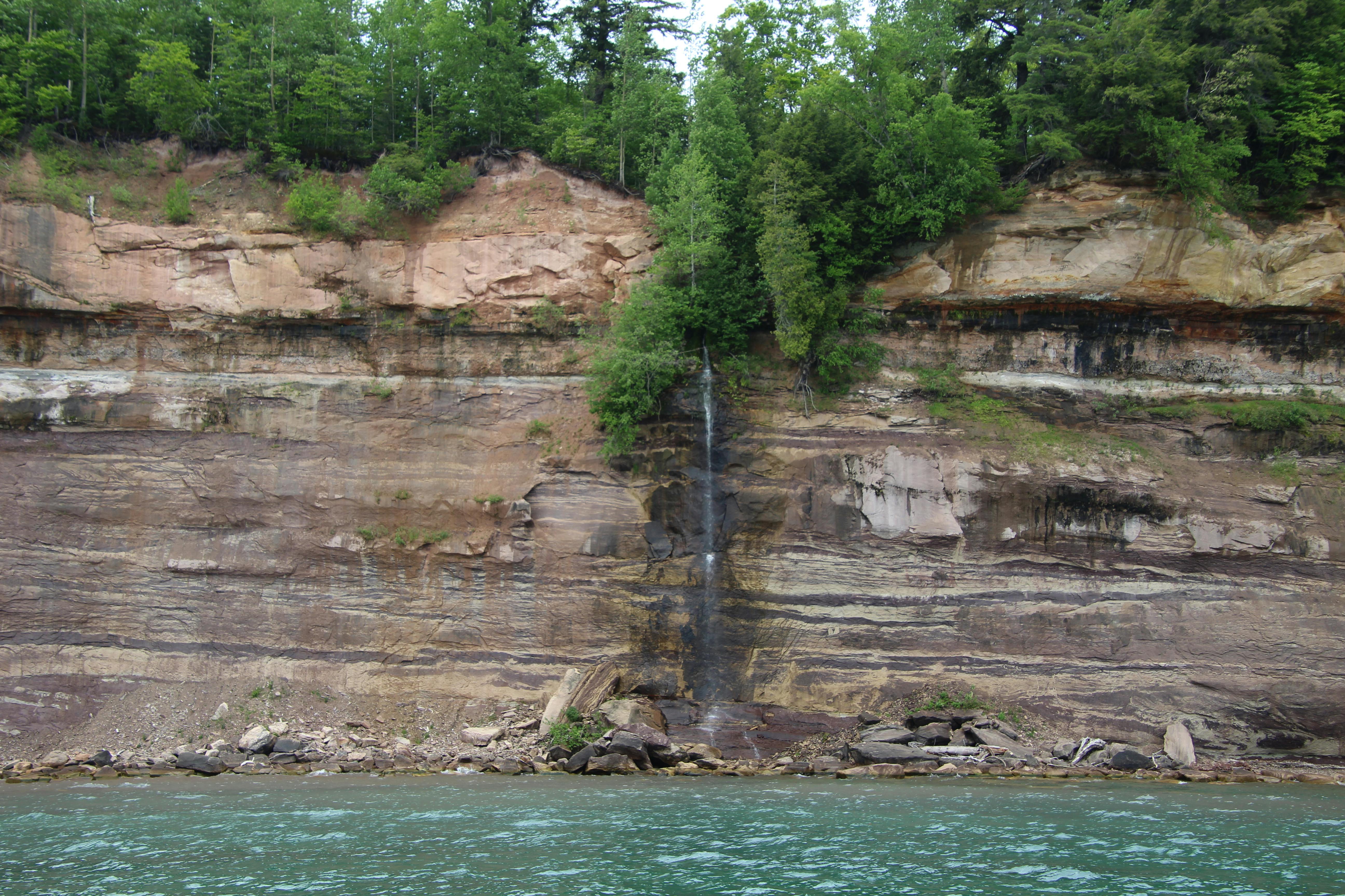 Beautiful view of the Pictured Rocks cliffs with a small waterfall in Michigan.