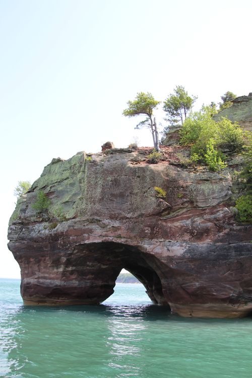 Free Majestic sea arch rock formation surrounded by clear blue water at Apostle Islands, perfect for travel enthusiasts. Stock Photo