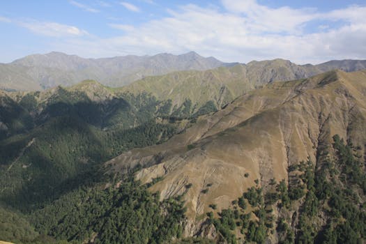 Breathtaking view of a mountain range with lush greenery under a clear blue sky.