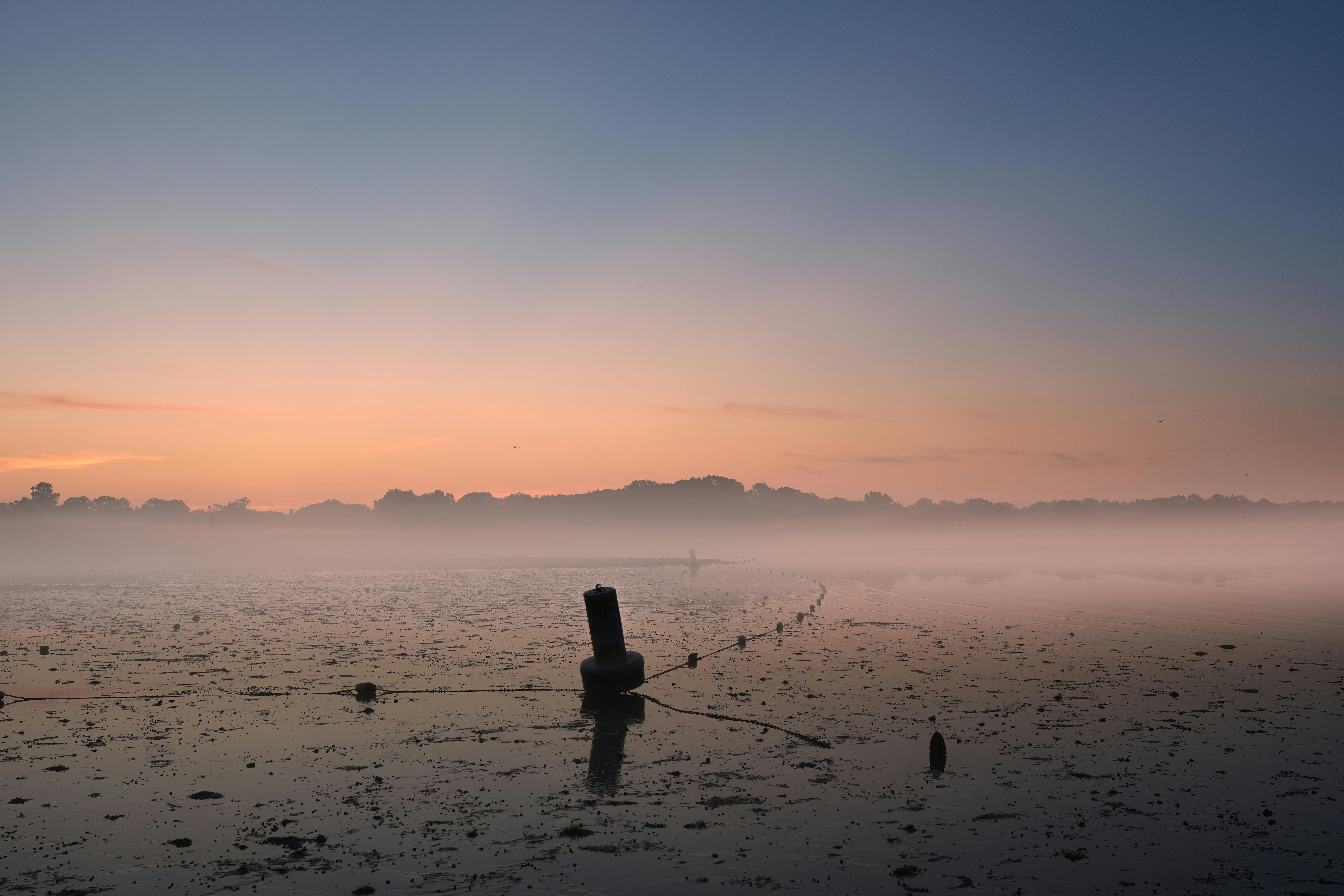 Serene sunrise at Cove Island Park with foggy horizon in Stamford, Connecticut.