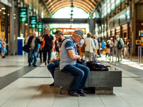 Free Crowds and seated people inside a bustling train station, showcasing architecture. Stock Photo