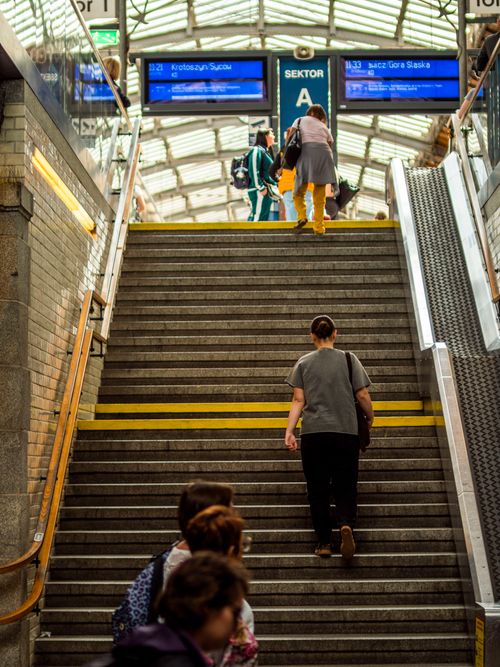 Free A lively scene of commuters ascending stairs at a busy train station. Stock Photo