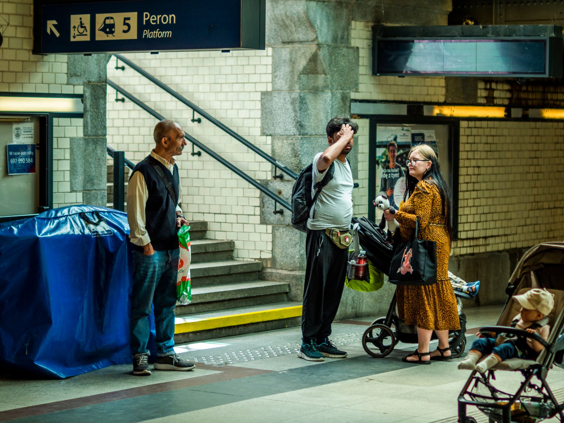 A candid scene at an underground subway platform with individuals in conversation.