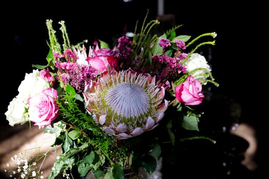 A stunning floral arrangement showcasing a variety of blooms with a prominent protea centerpiece.