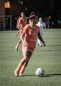 Female soccer players compete in an outdoor match in Chile, showcasing skill and teamwork.