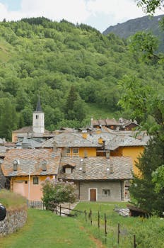 Beautiful mountain village nestled in Valle d'Aosta, Italy, surrounded by lush greenery.