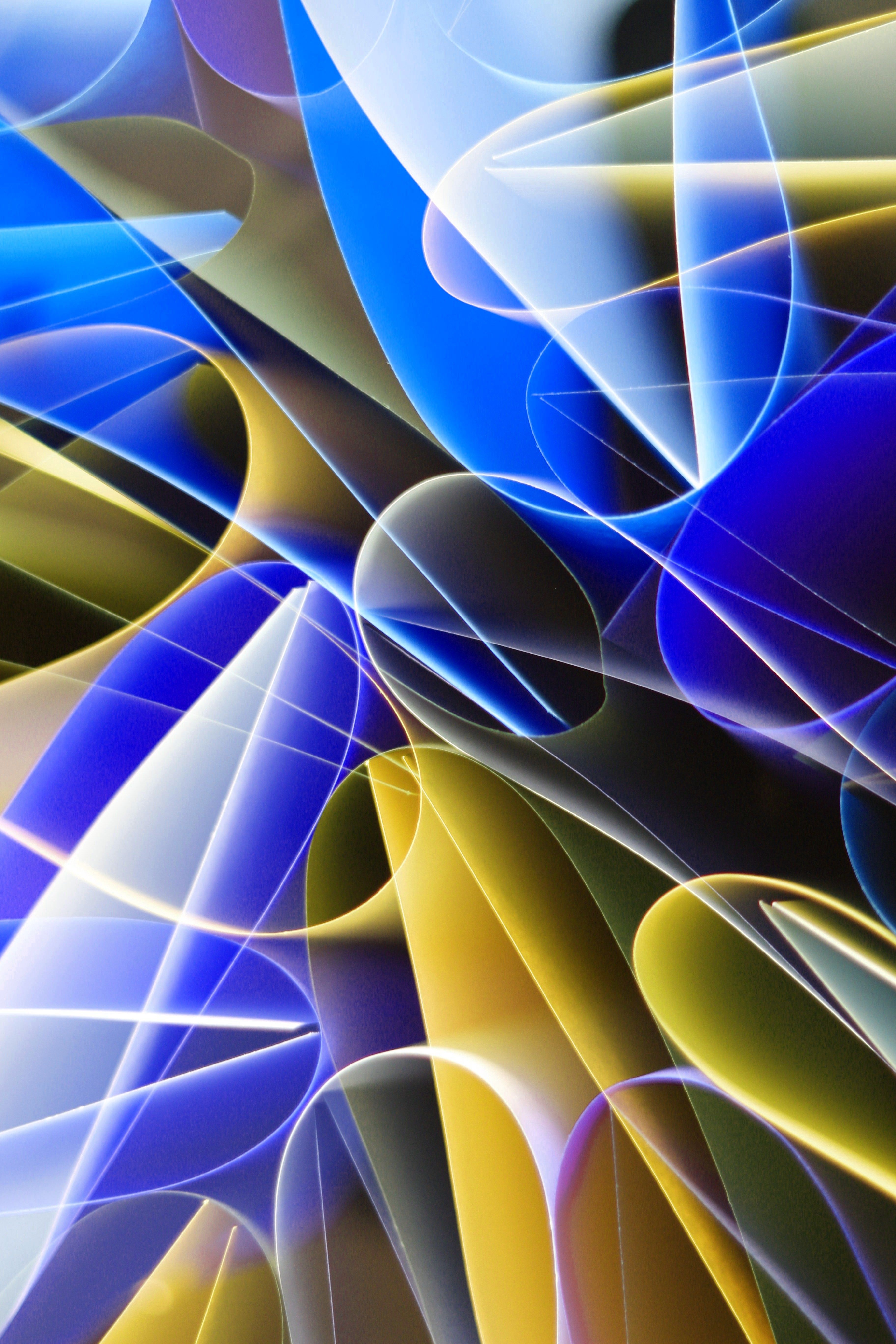 Dynamic abstract patterns of light with blue and yellow tones, creating a vibrant visual impact.