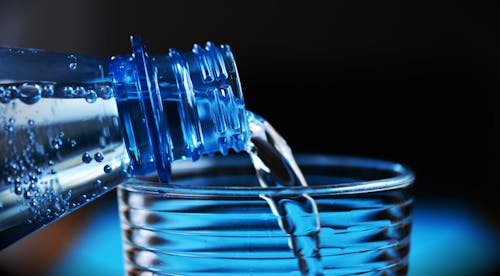 Close-up of Bottle Pouring Water on Glass