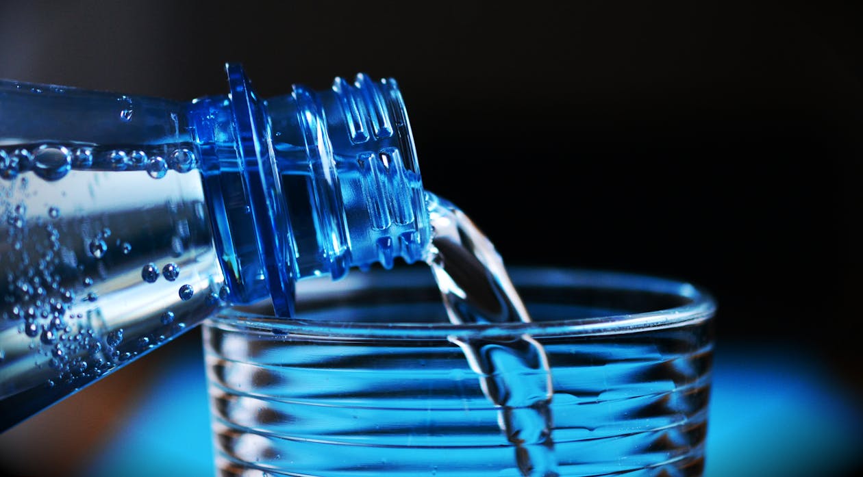 Free Close-up of Bottle Pouring Water on Glass Stock Photo