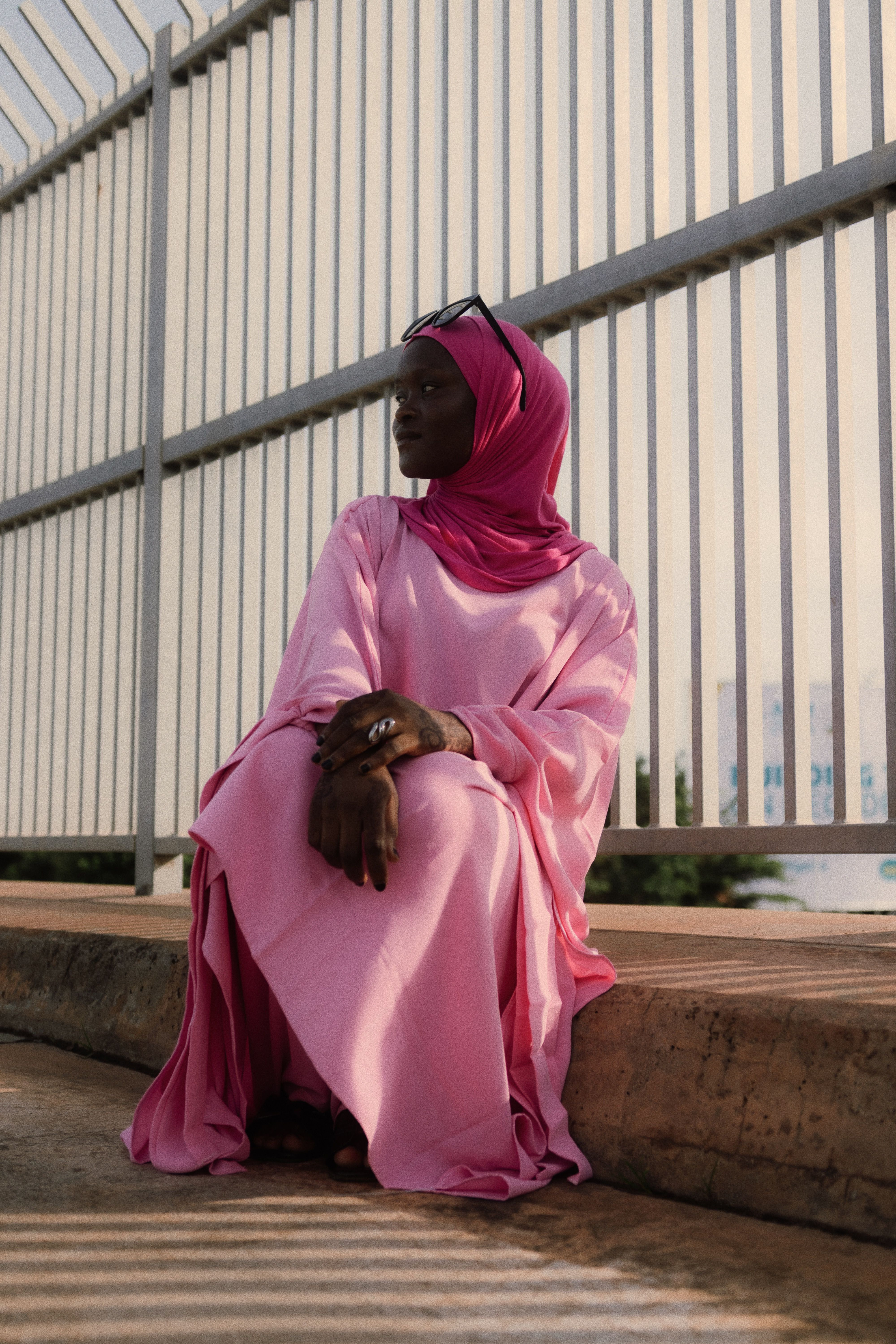 Elegant Woman in Pink Hijab Seated Outdoors · Free Stock Photo