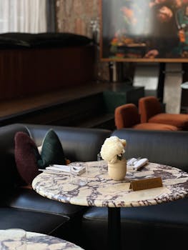 A reserved marble table with flowers in a stylish restaurant lounge setting, implying sophistication.
