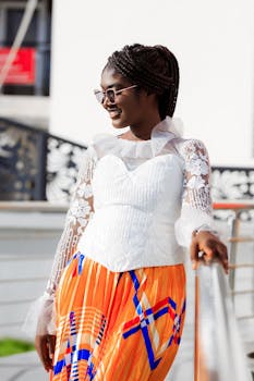 Confident woman in chic white lace top with vibrant skirt, enjoying sunny day outdoors.