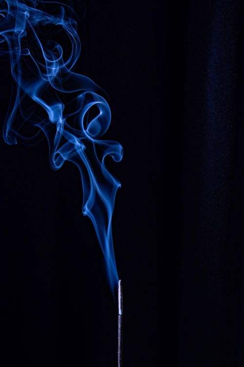 Free Capture of delicate blue smoke swirling on a dark backdrop, creating a mystical atmosphere. Stock Photo