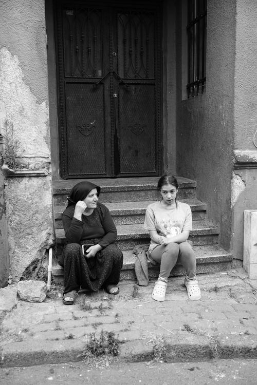 Free Black and white photo of two women sitting on urban steps, evoking a candid street atmosphere. Stock Photo
